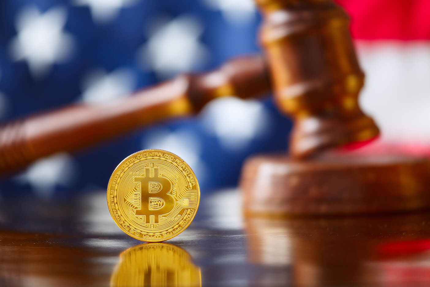 Gold bitcoin in front of a gavel and U.S. flag